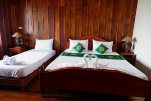 Postel nebo postele na pokoji v ubytování Kongmany Prestige Hotel
