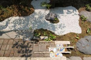 een tuin met een stenen pad en rotsen en aphaltphaltphalt bij Hashibaya TABI-NE in Kanazawa