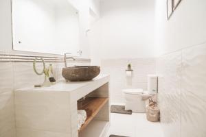 a white bathroom with a sink and a toilet at Naia Lombok in Kuta Lombok