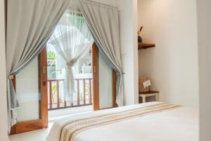 een slaapkamer met een bed en een raam bij Naia Lombok in Kuta Lombok