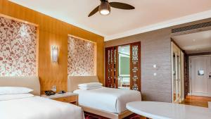 a hotel room with two beds and a table at InterContinental Grand Ho Tram in Ho Tram