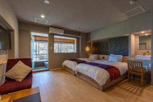 a bedroom with a large bed and a chair at TKP Lectore Hakone Gora in Hakone