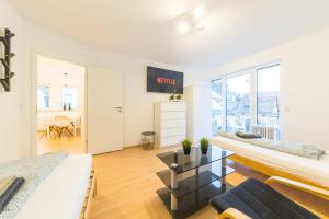 a living room with two beds and a table at NEW Luxury Apartment in Heilbronn, Ludwigsburg, Backnang, Stuttgart in Beilstein +3 photos