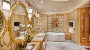 baño con bañera y espejo grande en InterContinental Grand Ho Tram en Ho Tram