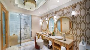 a bathroom with two sinks and mirrors and a shower at InterContinental Grand Ho Tram in Ho Tram