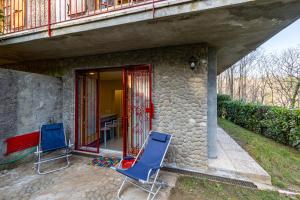 duas cadeiras azuis sentadas em frente a uma casa em Comfortable Home Vittoria Among Greenery - Happy Rentals em Marliana