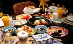 a table with food and drinks on a table at Valia Hotel Bangkok in Bangkok