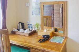 a desk with a mirror and a telephone on it at Ped Cottage in Nusa Penida