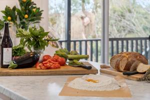 a counter with a cutting board with bread and vegetables at Kurrajong Holiday House - Family in Kurrajong +13 photos