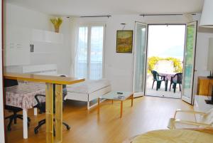 sala de estar con mesa y comedor en Studio Apartment Open Space with Terrace, en Argegno