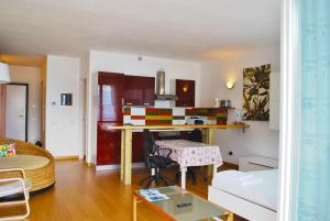 uma cozinha e sala de estar com uma secretária num quarto em Studio Apartment Open Space with Terrace em Argegno