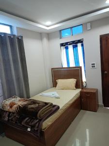 a small bedroom with a bed and a window at Hilsan Hotel in Bomdila