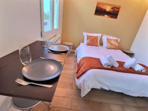 a bedroom with a bed with a table with a tray on it at Road Stop Studio *Paris*Disney*Gare* in Chelles