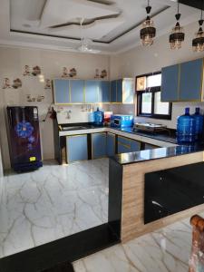 a kitchen with blue cabinets and a black counter top at Manidweepa farm house in Venkatāpur