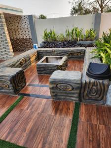 a patio with a wooden floor with plants on it at Manidweepa farm house in Venkatāpur