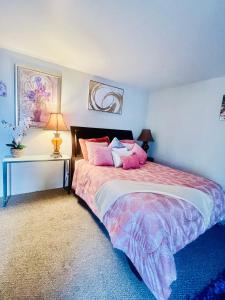 a bedroom with a bed with pink pillows and a table at Private Master Bedroom in Santa Clara