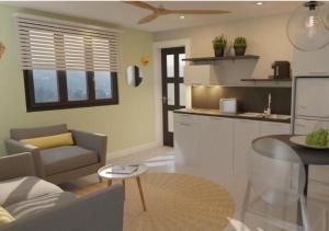 een keuken en woonkamer met een bank en een tafel bij Les Cerisiers - Exclusive Beach Residence Flic en Flac in Flic-en-Flac +3 foto's