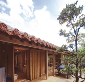 ein Dach auf einem Haus mit einer Holzterrasse in der Unterkunft かたあきの里 in Miyako-jima
