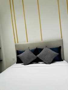 a bed with four pillows on top of it at Axon Suites KL Pavilion in Kuala Lumpur