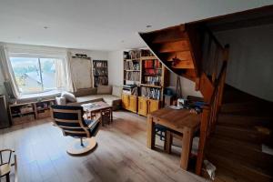 een woonkamer met een trap, een tafel en een stoel bij Grande maison familiale à Gerbetière en Chartreuse in Saint-Pierre-de-Chartreuse