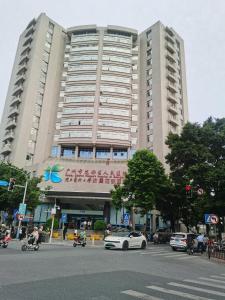 a large building with a car parked in front of it at Paco Hotel Guangzhou North Railway Station in Huadu