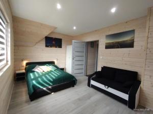 ein Schlafzimmer mit einem Bett und einem Sofa darin in der Unterkunft Luxury holiday homes with swimming pool, jacuzzi in Rewal