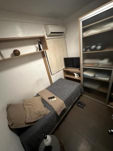 a small room with a bed and shelves at Ap do Doshe in Teresina