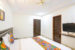 a bedroom with a bed and a flat screen tv at FabHotel Shirdi Park Inn in Shirdi