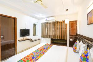 a hotel room with a bed and a tv at FabHotel Shirdi Park Inn in Shirdi
