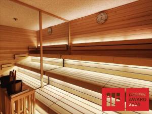 un sauna vide avec une horloge sur le mur dans l'établissement Hiranoya, à Gamagori