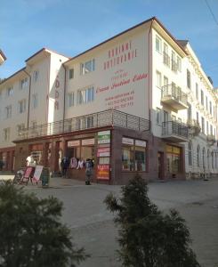 un gran edificio con gente parada frente a él en Apartmány ORAVA-EDDA, en Trenčianske Teplice
