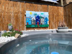 a swimming pool with a painting on a wooden wall at Simply Rus in Oudtshoorn