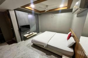 a bedroom with a large bed and a sink at Hotel Om Balaji in Ahmedabad