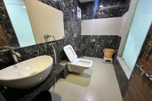a bathroom with a sink and a toilet at Hotel Om Balaji in Ahmedabad