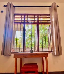 una ventana con una mesa de madera delante de ella en The Window, en Matara