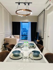 a dining room with a table with plates and bowls on it at Axon Suites KL Pavilion in Kuala Lumpur