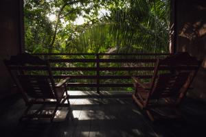 duas cadeiras sentadas no alpendre de uma casa em Kapievi Ecovillage em Puerto Maldonado