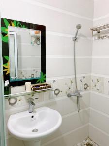 a white bathroom with a sink and a mirror at Bao Long Guest House in Cat Ba