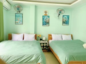 two beds sitting next to each other in a bedroom at Bao Long Guest House in Cat Ba