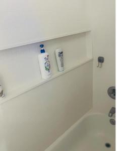 a bathroom with a tub with two bottles on a shelf at Private Master Bedroom in Santa Clara