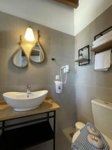 a bathroom with a sink and a toilet and mirrors at Harbour lights by Smaris Collection in Sisi