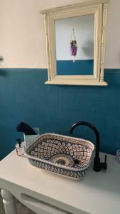 - un lavabo dans la salle de bains avec un panier dans l'établissement Villa Julia Veneria, à Sicca Veneria