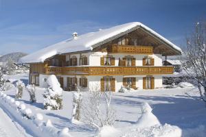 a large house covered in snow with snow covered trees at Ferienwohnung Bergkristall in Krün +9 photos