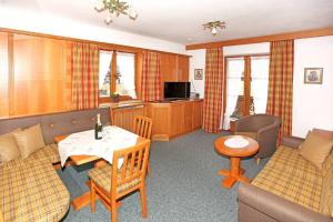 a living room with a couch and a table and chairs at Ferienwohnung Bergkristall in Krün