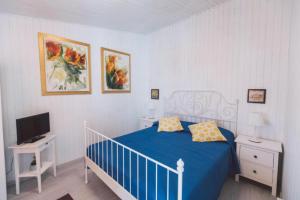 ein Schlafzimmer mit einem blauen Bett und einem TV in der Unterkunft Apartment with terrace overlooking the sea - air conditioned - wi-fi in Syrakus