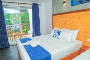 a bedroom with a large bed and a balcony at Mount End Hotel Nuwara Eliya in Nuwara Eliya