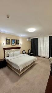 a large bedroom with a large white bed in it at Hayot Hotel in Tashkent