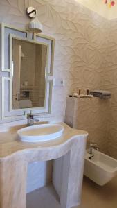 La salle de bains est pourvue d'un lavabo, d'un miroir et d'une baignoire. dans l'établissement Terrace Suites Iasi, à Iaşi