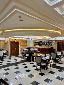 a restaurant with tables and chairs in a room at Hayot Hotel in Tashkent