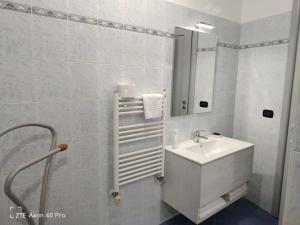 La salle de bains blanche est pourvue d'un lavabo et d'un miroir. dans l'établissement Monovano Eumorfia, à Triggiano